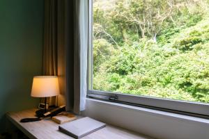 a window with a desk with a lamp and a book at Hayama Umino Hotel in Hayama