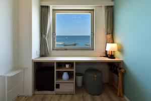 a window in a room with a desk and a table at Hayama Umino Hotel in Hayama