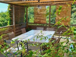 un patio avec une table et des chaises sur une terrasse dans l'établissement Gîte Maison Faure, à Alvignac