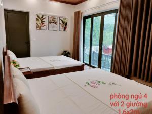 two beds in a room with a window at Nobita Villa Venuestay in Hanoi
