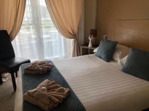 a hotel room with a bed with towels on it at Royal Grosvenor Hotel in Weston-super-Mare +24 photos