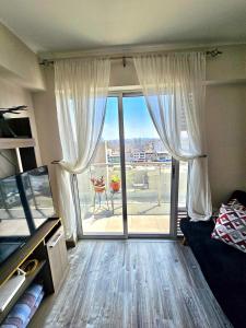 een kamer met een groot raam met uitzicht op een patio bij Dpto acogedor con terraza privada in Lima