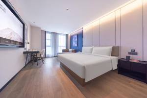 Rúm í herbergi á Atour Hotel Yangchun Lake Wuhan High Speed Rail Station