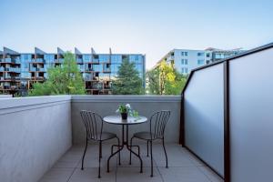 un piccolo tavolo con sedie su un balcone con edifici di Modern apt in heart of the city a Canberra