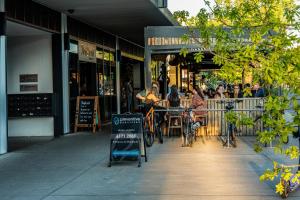 un gruppo di persone seduti ai tavoli fuori da un ristorante di Modern apt in heart of the city a Canberra Altre 7 foto
