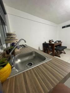 - un comptoir de cuisine avec un évier et une table dans l'établissement Departamento los pinos 1, à Zurumútaro