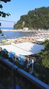 ein Strand mit Sonnenschirmen und Menschen im Wasser in der Unterkunft Chrisi Akti Hotel in Skala Potamias