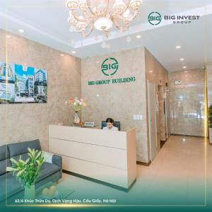 a woman sitting at a reception desk in a lobby at BIG Apartment Ha Noi in Hanoi