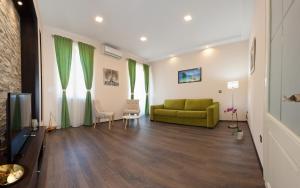 a living room with a green couch and a television at Apartment Bacvice in Split