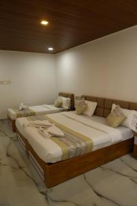 two beds sitting next to each other in a room at Grand Tamim Hotel in Mangalore