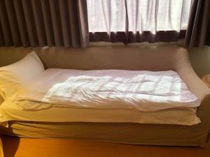 Ένα ή περισσότερα κρεβάτια σε δωμάτιο στο Large family room near Metro Taipei station for comfort and convenience, where 5 can relax and create unforgettable moments