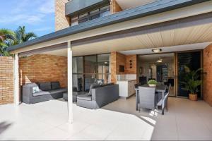 an outdoor patio with chairs and a table at Beachside Oasis-Walk to Alex Beach in Alexandra Headland