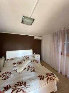 a bedroom with a bed with a white bedspread and a window at Pensiunea Felixanda in Baile Felix