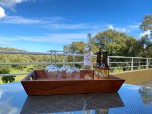 a wooden tray with bottles and glasses on a table at Les arbousiers de Murateddu in Porto-Vecchio +1 photo