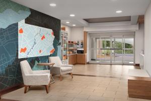 a living room with two chairs and a map on the wall at Holiday Inn Express & Suites by IHG Chambersburg by IHG in Chambersburg