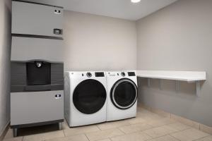 a laundry room with a washing machine and a counter at Holiday Inn Express & Suites by IHG Chambersburg by IHG in Chambersburg
