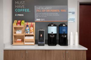 a counter with a bunch of bottles of coffee on it at Holiday Inn Express & Suites by IHG Chambersburg by IHG in Chambersburg +36 photos
