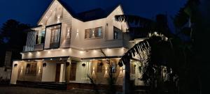 a white house with lights on it at night at Rockland Holidays in Ramakkalmedu
