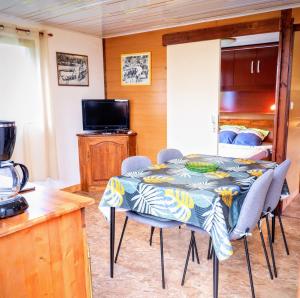 a room with a table and chairs and a bedroom at Bienvenue à l'Oasis Bungalow Paisible in Les Avirons