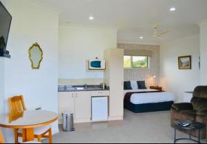 a hotel room with a bed and a table and a kitchen at Austin Heights - Kaikoura in Kaikoura