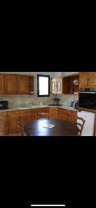 a kitchen with wooden cabinets and a wooden table at Maison de vacances in Saint-Trojan-les-Bains