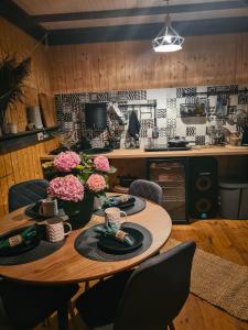 a kitchen with a wooden table with flowers on it at Million star hotel Latgale in Nastrova +91 photos