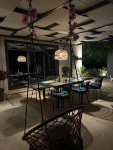 een terras met een schommel met een tafel en stoelen bij Villa secrecy in Lixouri