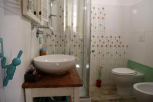 a bathroom with a sink and a shower with a toilet at Famme sta cuiete appartamento Napoli centro in Naples