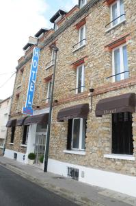 a brick building with a sign on the side of it at Hôtel Patio Brancion in Malakoff