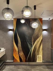 a large painting on the wall in a room with lights at Osaka Ebisu Hotel in Osaka