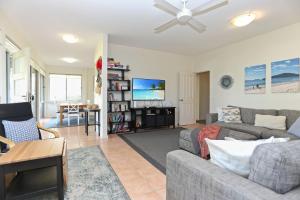 a living room with a couch and a tv at Lovely Pet Friendly Beach House in Hawks Nest