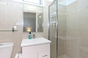 a bathroom with a toilet and a sink and a shower at Lovely Pet Friendly Beach House in Hawks Nest +14 photos