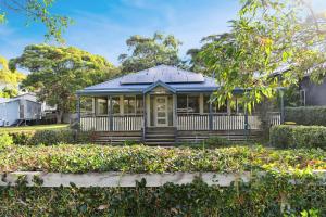 a house with a blue roof and a porch at Lovely Pet Friendly Beach House in Hawks Nest