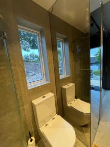 La salle de bains est pourvue de toilettes, d'une douche et d'une fenêtre. dans l'établissement Sjönära pärla, à Vagnhärad