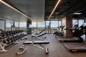 a gym with a lot of exercise equipment and windows at Sophisticated Designer Condo w City & Bay Views in Melbourne
