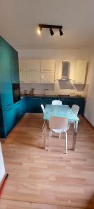 a kitchen with a blue table and white chairs at Casa Giulia in Genoa