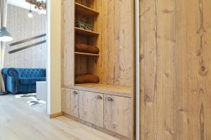 a wooden cupboard in a room with a blue couch at Ski Apartment Hillside in Dolný Kubín