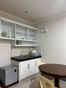 a kitchen with white cabinets and a table and a sink at Ashelma resort in Dauis