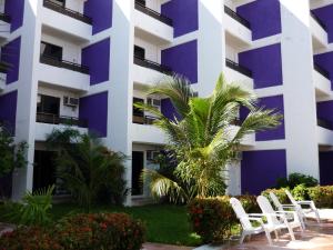 a building with white chairs in front of it at Hotel Debliz in Campeche
