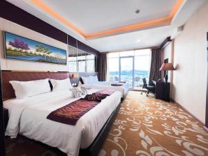 una camera d'albergo con due letti e una grande finestra di Batam City Hotel a Nagoya Altre 37 foto