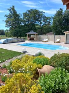 a garden with a swimming pool and a gazebo at La petite maison dans le Quercy in Cayriech