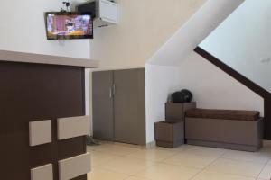 a room with a staircase with a tv on the wall at Anna Hotel in Trivandrum