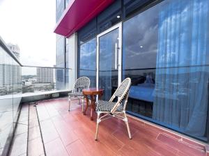 un balcone con due sedie e un tavolo su un edificio di Batam City Hotel a Nagoya