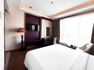 una camera d'albergo con un letto bianco e una finestra di Batam City Hotel a Nagoya