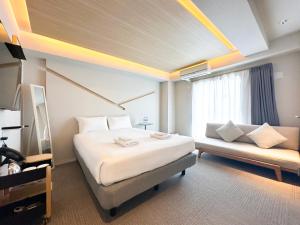 a hotel room with a large bed and a couch at Osaka Ebisu Hotel in Osaka