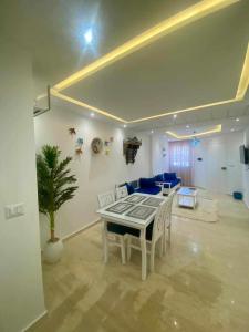 un salon avec une table et un canapé bleu dans l'établissement ResidenceHbiba-Appart2-RDC, à Ḩammām al Ghazzāz