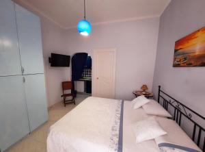 a bedroom with a white bed and a blue light at Casa Simonetta il Roseto in Ponza