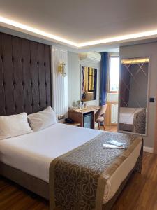 a bedroom with a large bed and a desk at Gumus Palace Gungoren in Istanbul