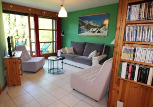 a living room with a couch and chairs and a tv at Charmant Appartement dans Chalet in Briançon