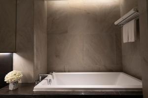a bathroom with a large tub in a room at Walton Suites Sukhumvit in Bangkok +74 photos